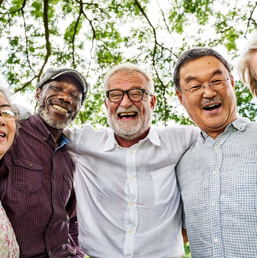 Group of friends smiling after learning how dentures are made in Cleveland 