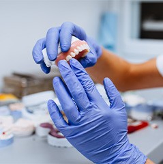 Dental technician holding a full denture