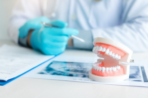 Closeup of model dentures sitting on dental paperwork 